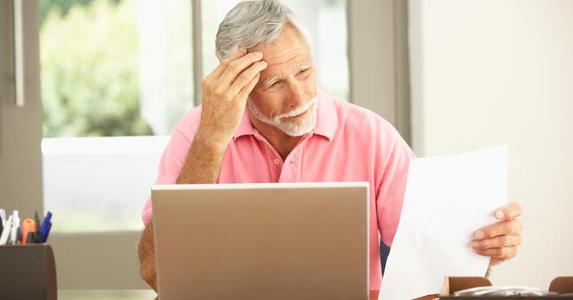 How long can that bad debt hang over me? Man grimacing at paper in his hand © iStock