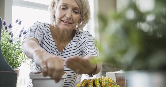 Survivor's vs. spousal Social Security benefits A woman gardening in her home | Hero Images/Getty Images