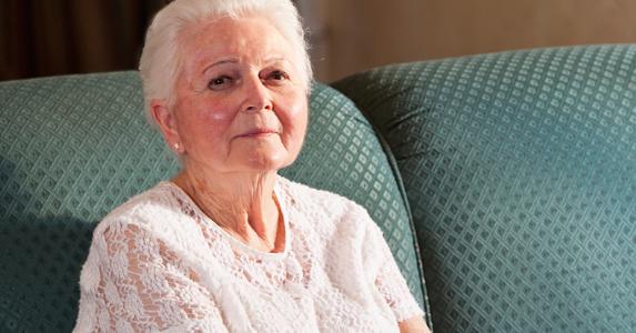 Senior woman sitting on couch © iStock