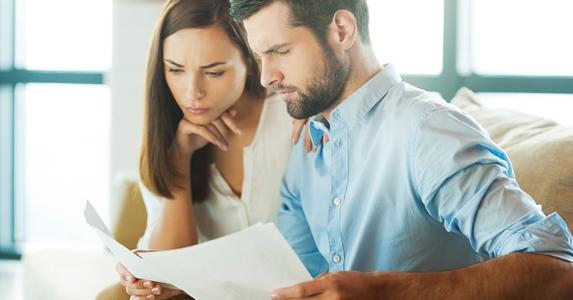 Serious young couple comparing documents © iStock