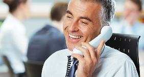 Older man on phone at desk © Stokkete/Shutterstock.com