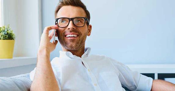 Smiling man wearing glasses on a phone call © baranq/Shutterstock.com