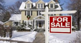 Snow covered house with for sale sign in foreground © Andy Dean Photography/Shutterstock.com