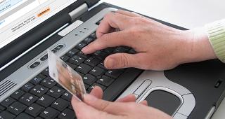 Online purchase with credit card © Ingvald Kaldhussater/Shutterstock.com