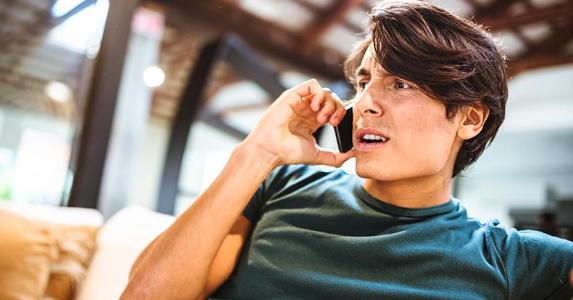 Identity thief got you? Here's how to report it Upset young man on the phone | iStock.com/franckreporter