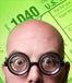 Wacky man wearing coke-bottle glasses in front of tax forms, green background