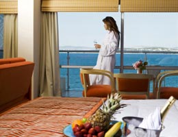 ways-to-save-summer-vacation-3-discount-lg Woman in hotel room with water view