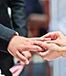 Wedding bride placing ring on groom © zhaoyan/Shutterstock.com