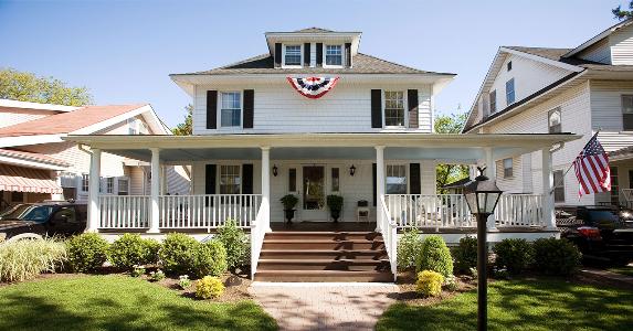 Which mortgage is for you? Conventional, FHA, VA Colonial-style house with flags hanging | Nine OK/Getty Images