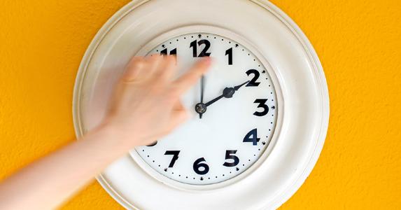 White clock on yellow wall, set to 12