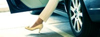 A woman's foot stepping out of a vehicle with a yellow heel on 