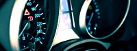 A close-up of the gages on a car above the steering wheel