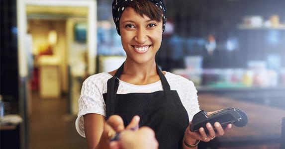 Woman holding chip card reader © Uber Images/Shutterstock.com