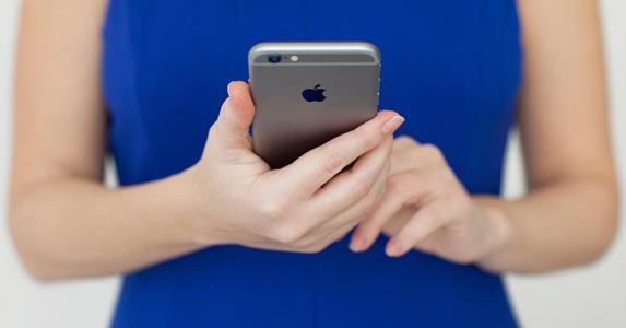 Inspect a new neighborhood with these 4 mobile apps Woman in blue dress holding iPhone | iStock.com/Prykhodov