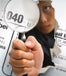 Woman ripping through "First time Homebuyers" tax credit form from behind, holding a magnifying glass inspecting fine print