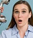 Woman looks shocked, man's hand holding old telephone receiver up to her ear