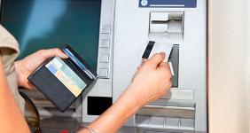Woman using debit card at ATM machine © Aleksandar Todorovic / Shutterstock.com
