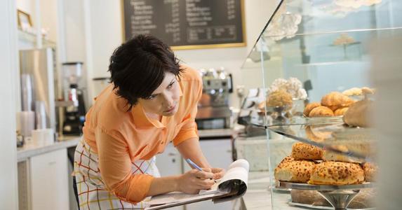 6 retirement plans for small business owners Baker checking her stock in display case | Hero Images/Getty Images