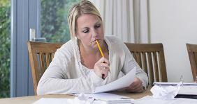 Worried woman looking over bills © Twin Design/Shutterstock.com