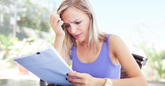 Worried woman looking at letter or statement © iStock