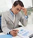 Young Asian man at desk reviewing charts © Dragon Images/Shutterstock.com