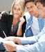 young couple reviewing documents with advisor