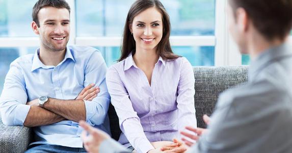 Financial planners: Not just for millionaires anymore Young couple sitting on a couch meeting with an adviser © Edyta Pawlowska/Shutterstock.com