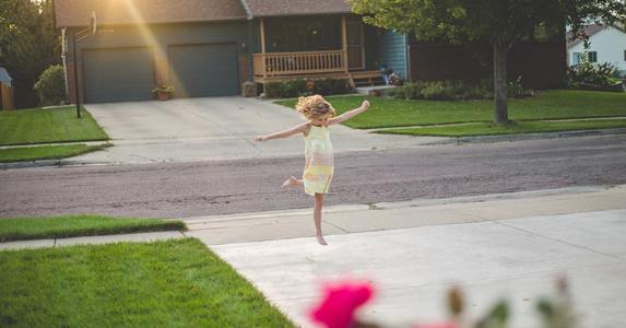 How to buy part of neighbor's driveway and land Young girl playing in driveway | Annie Otzen/Getty Images