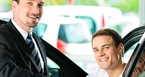 Young man at car dealership looking at new car © Kzenon/shutterstock.com