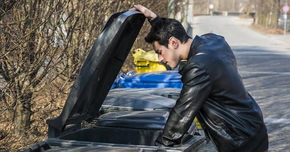 How to protect yourself from credit card fraud Young man searching trash bins | Stefano Cavoretto/Shutterstock.com