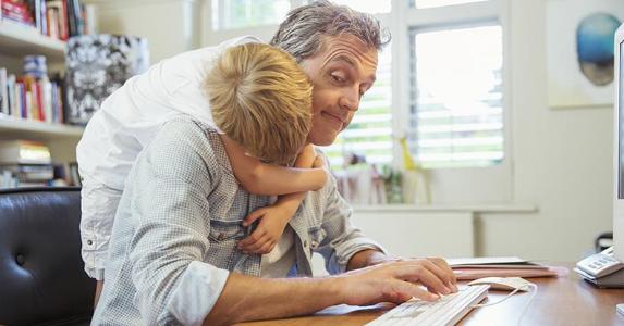 13 ways to cut your taxes without itemizing Young son hugging dad working from home office | Paul Bradbury/Getty Images