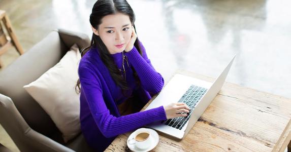 5 things young adults must know about credit Young woman in purple sweater using laptop computer | iStock.com/visionchina