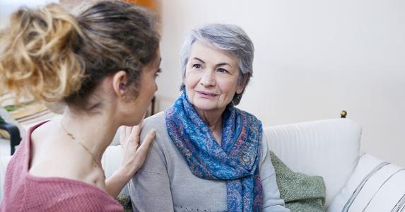 Young woman sitting with senior woman on couch © Image Point Fr/Shutterstock.com