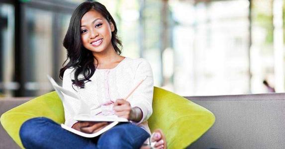How to fill out the FAFSA in record time Young woman sitting on green chair, writing on notebook © arek_malang/Shutterstock.com