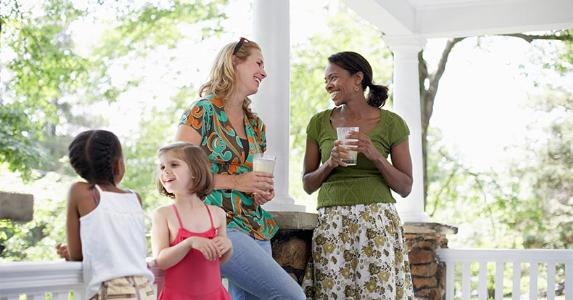 Moms and daughters on playdate in house's front porch | Sean Justice/Getty Images
